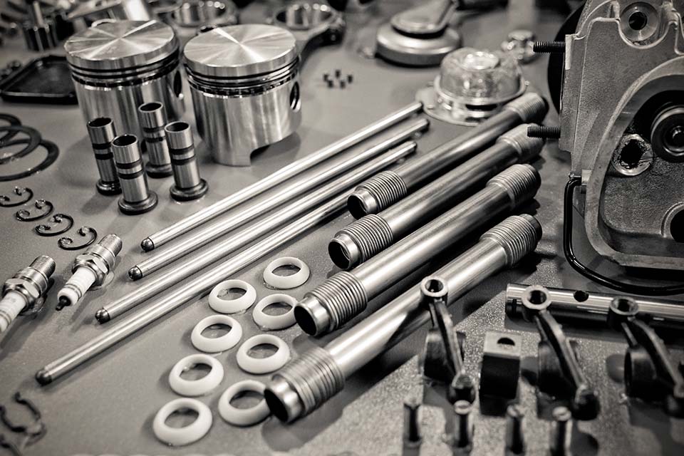 collection of sepia toned precision auto engine parts laid out in a workshop